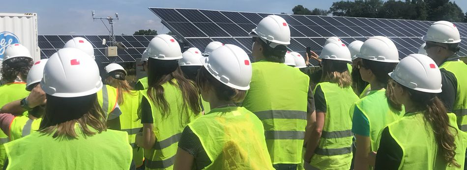 group in safety gear viewing solar pannels