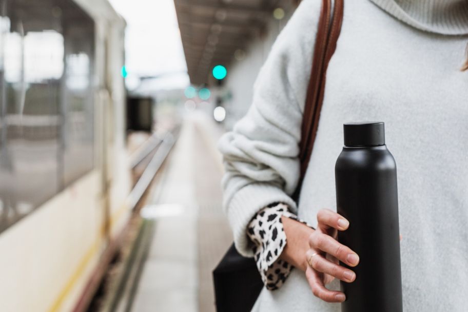 person carrying reusable water bottle