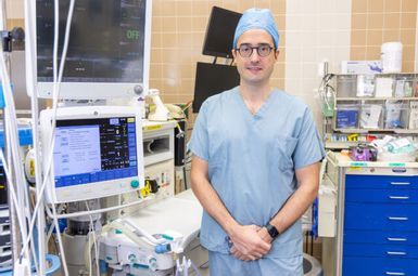 David Hovord, assistant professor of anesthesiology and one of the project leads for the Green Anesthesia Initiative, is shown in an operating room with an anesthesia machine in the background. (Photo courtesy of Michigan Medicine)