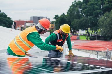 Two people working with a solar array