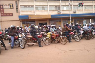 Motorcycle taxis, known as boda bodas, wait on the side of the road in Kampala, Uganda. Image credit: Tom Courtright