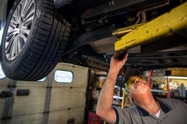 Illi’s Auto Service owner Larry Young works on a car in his shop. Photo: Marcin Szczepanski/Michigan Engineering