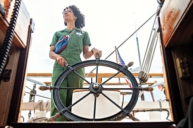 Malika Stuerznickel, a doctoral candidate in anthropology, steers the Inland Seas schooner on the Detroit River.