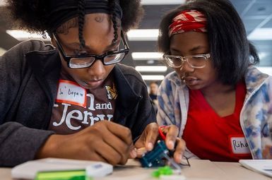 Ja’Coya Jordan and Rihanna Goree fill up the hydrogen balloon, connected to the electrolyzer (blue box). Credit: Marcin Szczepanski, Michigan Engineering.