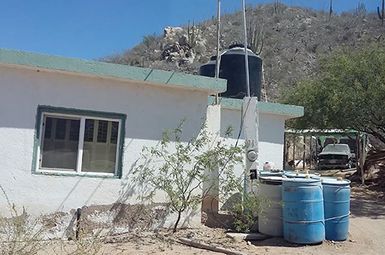 Small tanks of water outside of a home in the desert