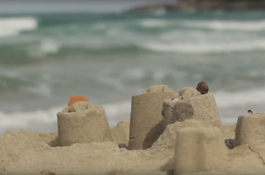 sandcastles with waves in the background
