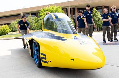 Terry Li, lead vehicle engineer for the 2023 Michigan Solar Car Team, pushes Astrum into position for a photo shoot in Ann Arbor, MI. Photo: Jeremy Little, University of Michigan College of Engineering.