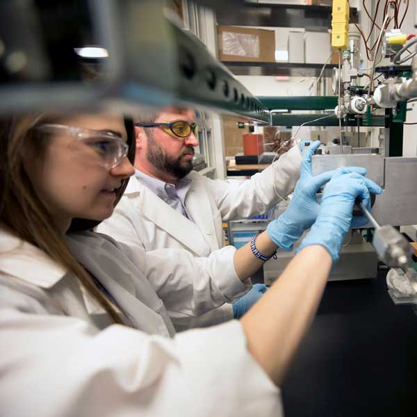 Researchers in a lab wearing safety equipment