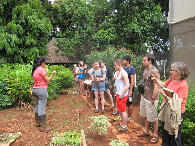 A farmer speaking to a group of students at a farm