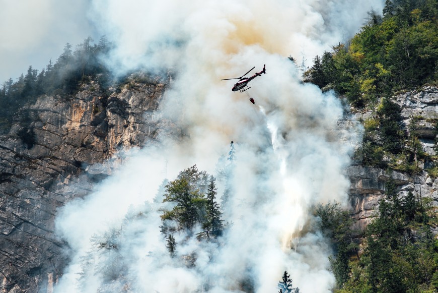 a helicopter extinguishing a forest fire